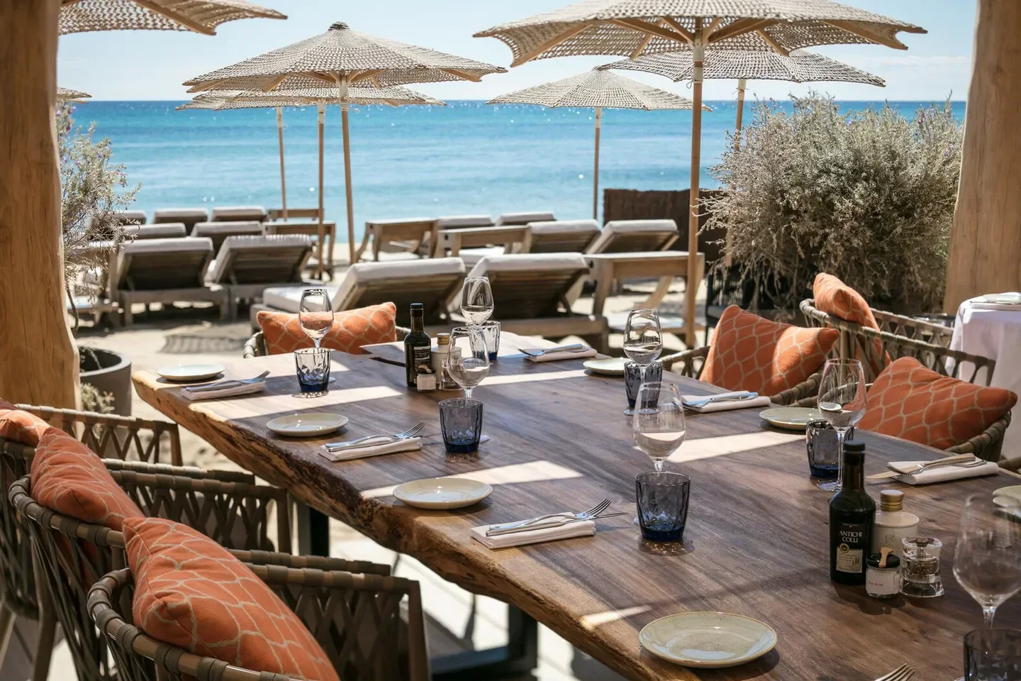 Dining table at Byblos Beach restaurant in Saint-Tropez, with beach view.