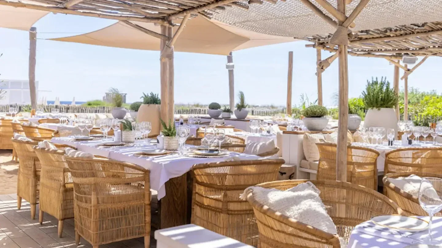 Outdoor dining at Clubs Les Palmiers in Saint-Tropez, with beach views and elegant decor.
