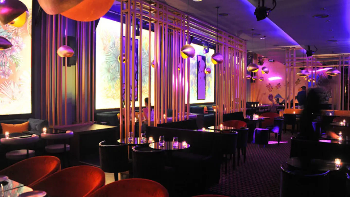 Elegant interior of GAIO restaurant in Saint-Tropez, with modern design and dim lighting.