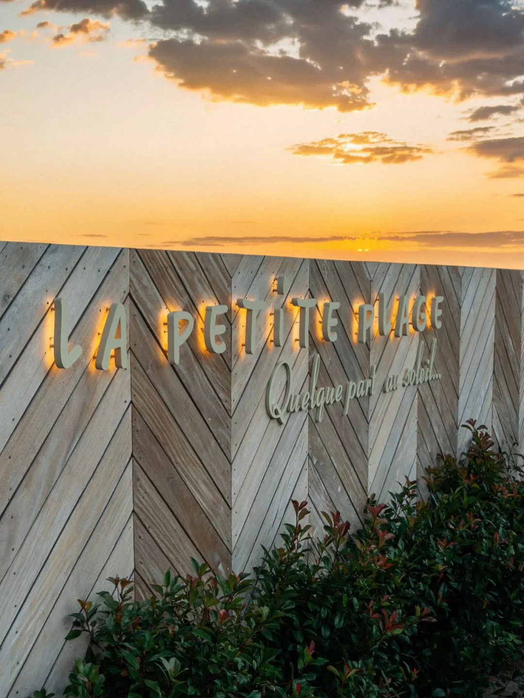 La Petite Plage nightclub exterior signage lit up at sunset in the city