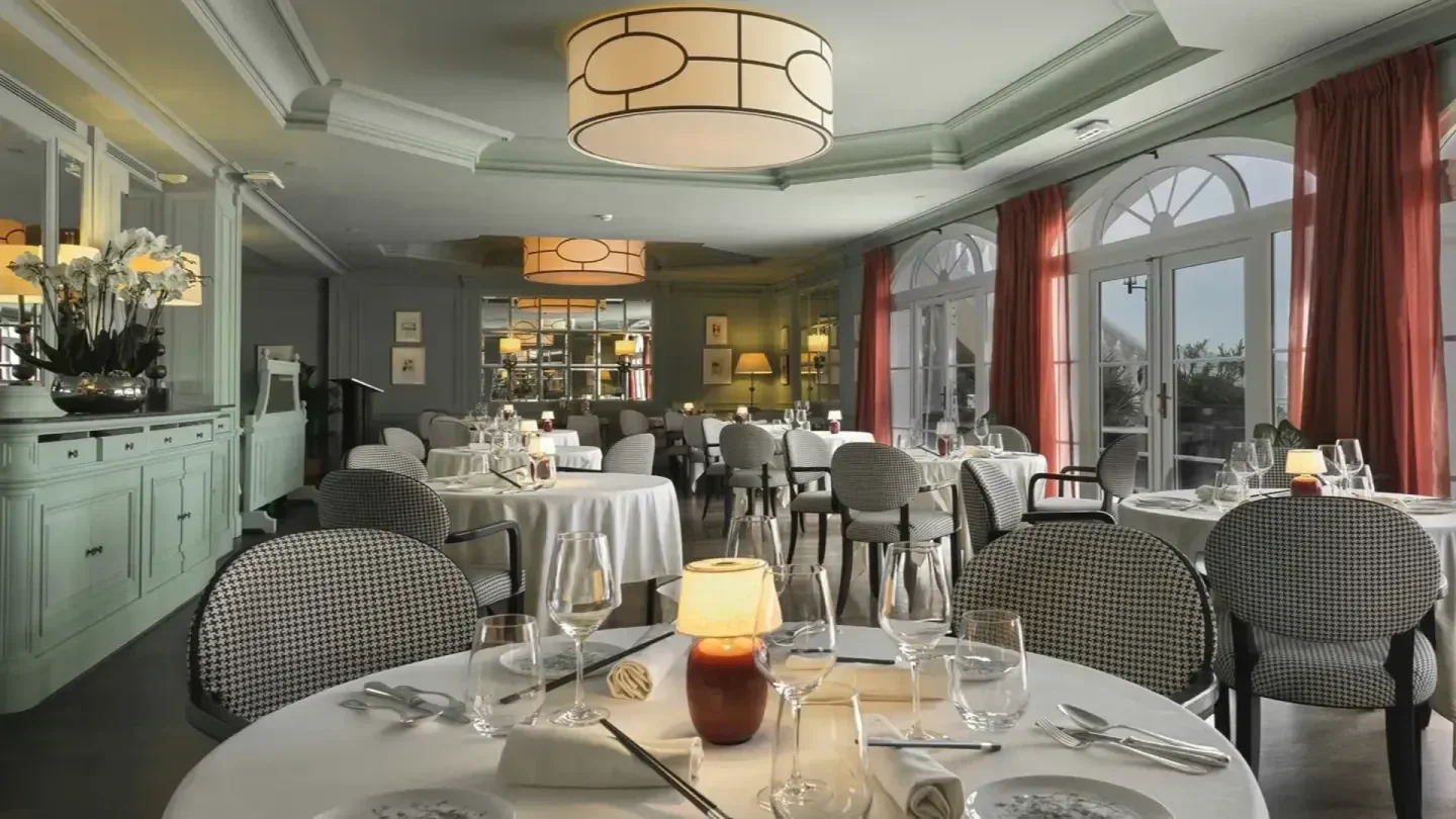 Elegant dining room interior at L'Indochine club in Saint-Tropez, with round tables