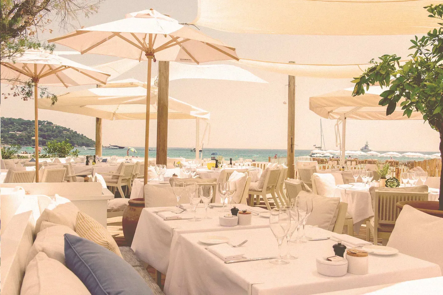Beachfront dining at Loulou Ramatuelle in Saint-Tropez, with umbrellas and ocean views.