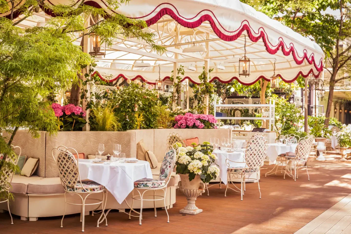 Outdoor dining at Maison Revka restaurant in Saint-Tropez, elegant setting with flowers and tables.