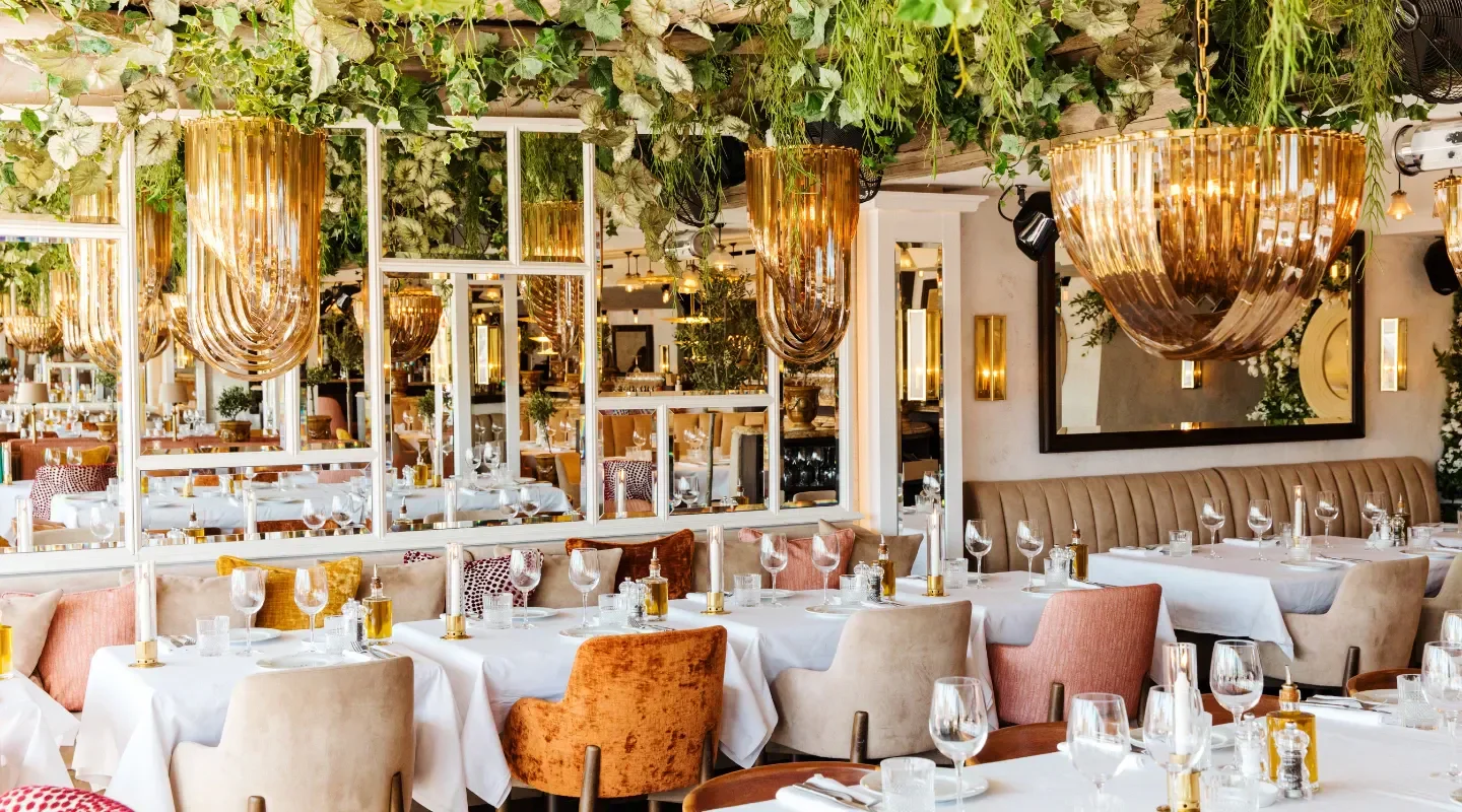 Elegant interior of NOTO restaurant in Saint-Tropez, featuring chandeliers and stylish decor.