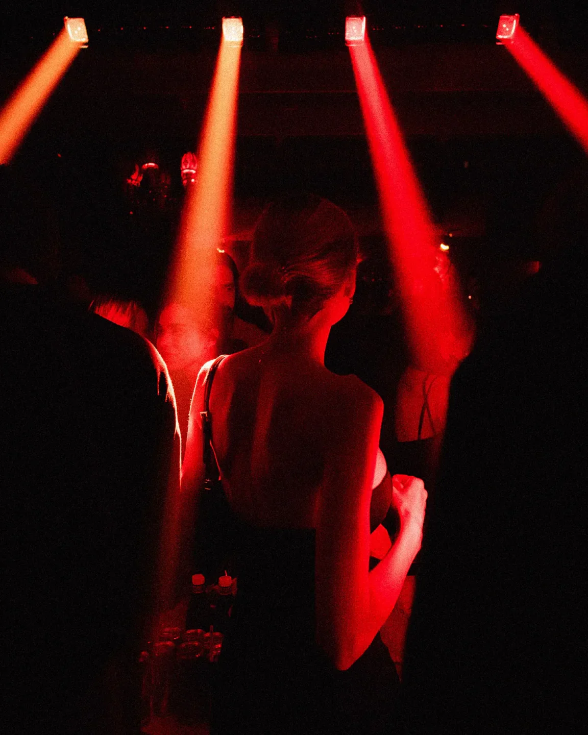 Atmospheric red lighting at Raspoutine nightclub in Saint-Tropez with silhouettes of people dancing.
