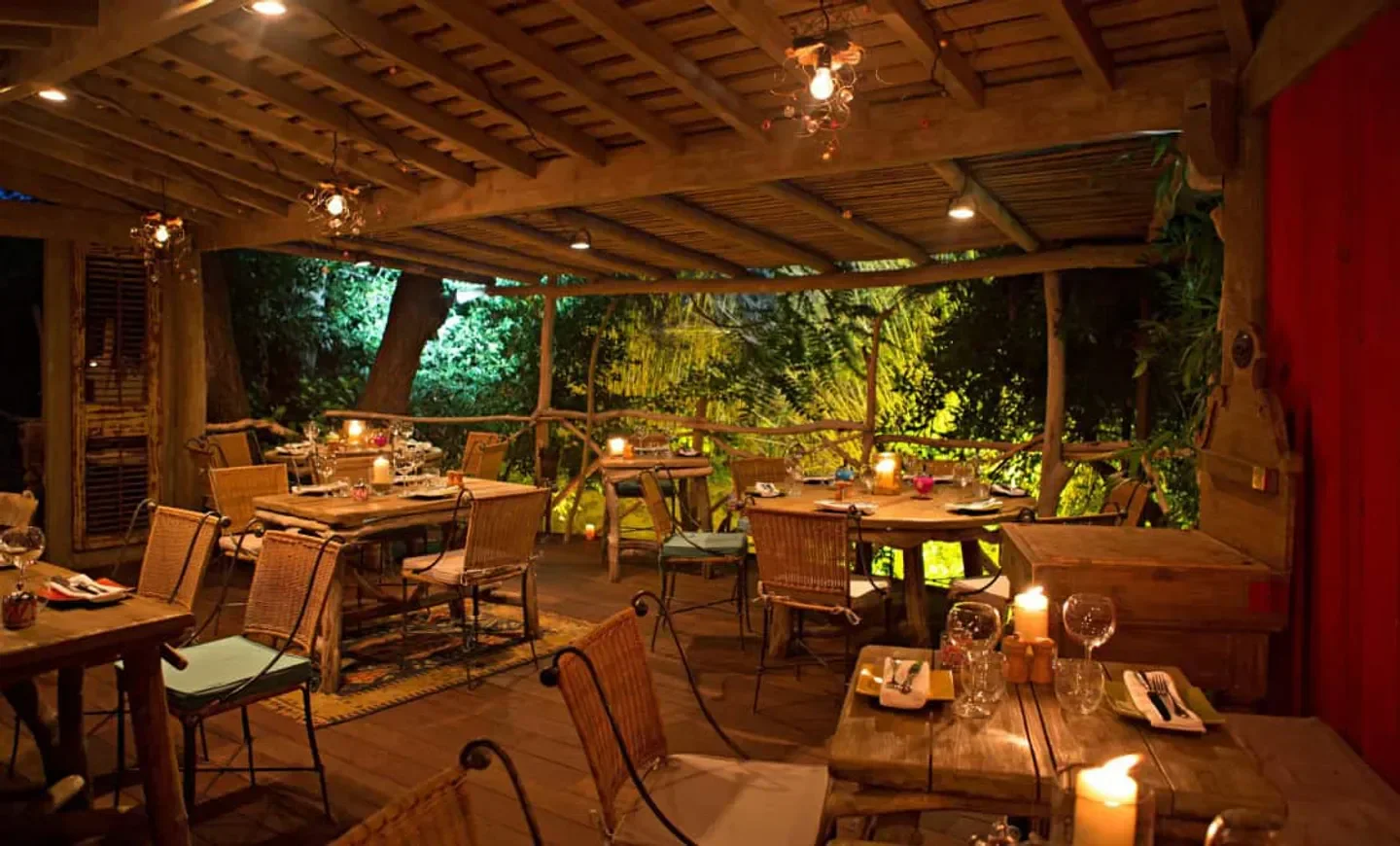 Cozy dining area at Sauvageonne in Saint-Tropez, with candlelit tables and a natural setting.
