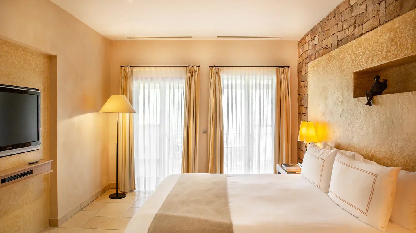 Cozy bedroom at Terre Blanche in Saint-Tropez, featuring a comfortable bed and warm lighting.