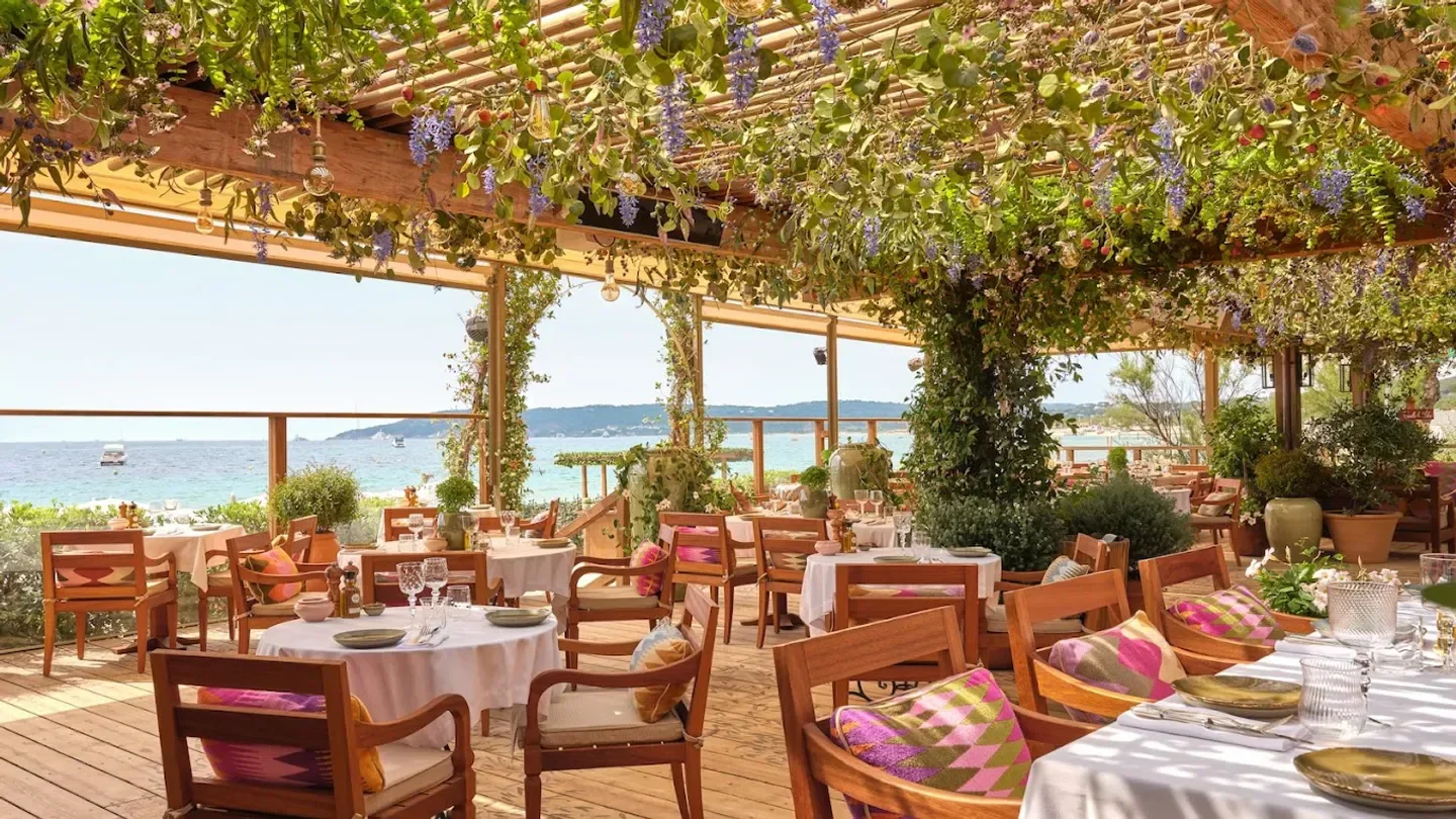 Restaurant seating at Tropezina Beach, Saint-Tropez, with ocean view and floral decor