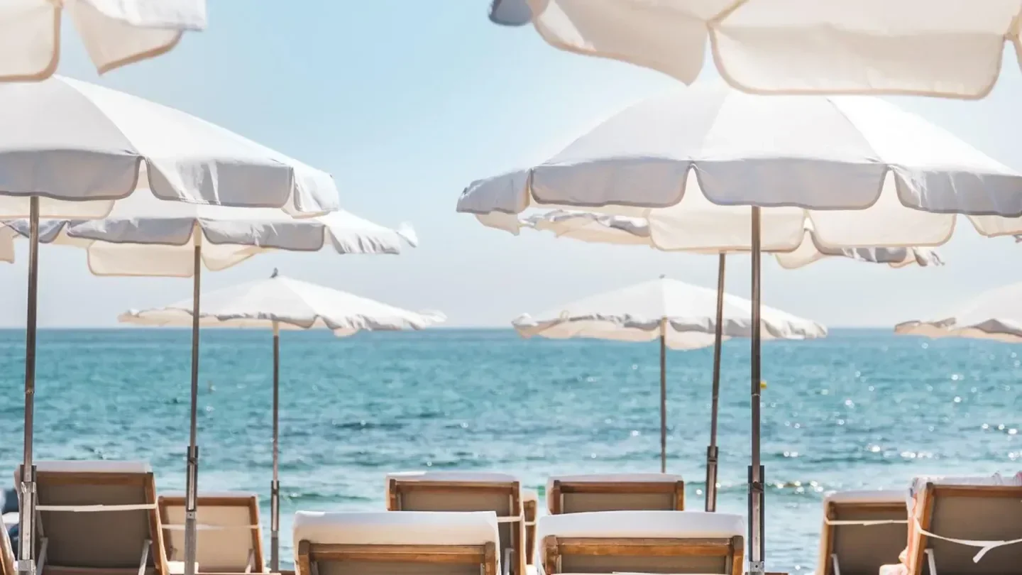 Beach scene at Tropicana La Plage in Saint-Tropez with white umbrellas and ocean view