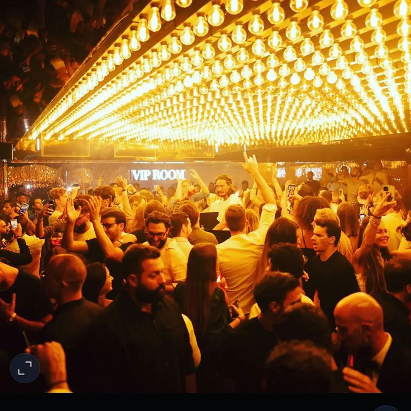 Energetic crowd at VIP Room nightclub in Saint-Tropez, under warm golden lighting.